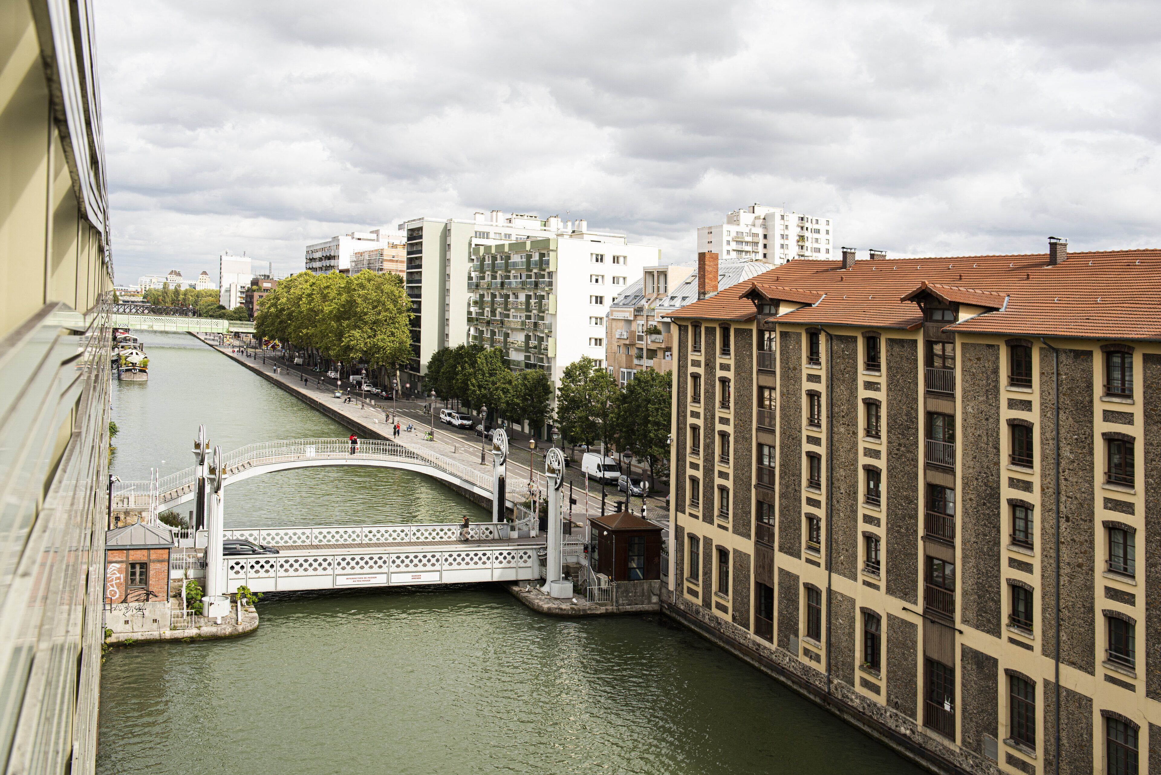 Ein Fluss mit einer Brücke, Gebäuden und einem Fußweg.