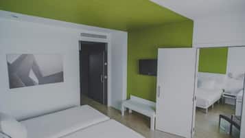 Una habitación de hotel moderna con una cama, un banco, un televisor y un armario.