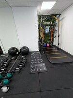A gym with exercise equipment, including dumbbells, kettlebells, and resistance bands.