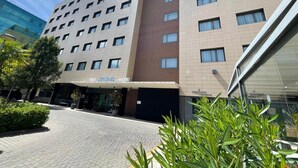 Un hotel con fachada moderna, varios pisos y una entrada destacada.