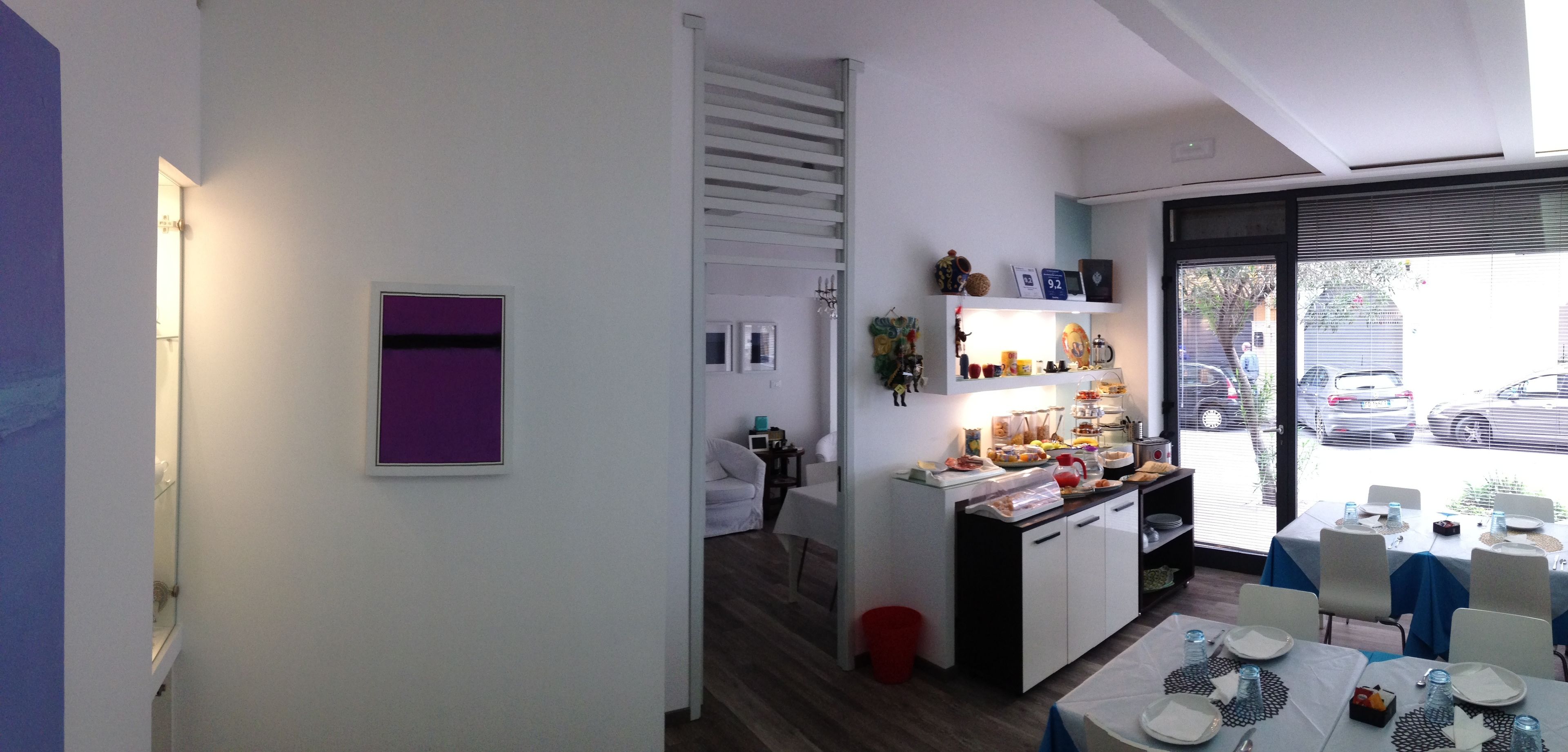 A modern kitchen with a dining area, featuring a built-in oven, a small island, and a view through the window.