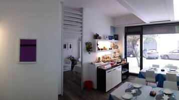 A modern kitchen with a dining area, featuring a built-in oven, a small island, and a view through the window.