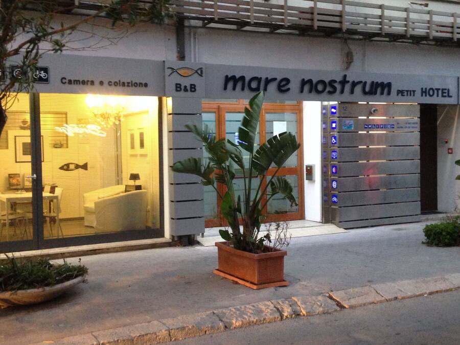 A hotel entrance with a sign reading "mare nostrum petit hotel" and a visible elevator with accessibility symbols.