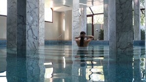 A spacious indoor swimming pool with marble columns and a clear glass floor, surrounded by high ceilings and large windows. - Es Saadi Marrakech Resort Palace (Marrakech)