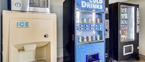 Vending machines for cold drinks and ice dispensers in a commercial setting.