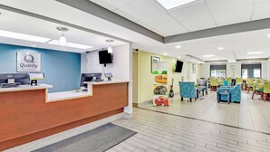 A hotel reception area with a reception desk, computers, and seating area. - Quality Inn White House (White House)
