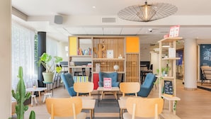 A modern indoor space with wooden furniture, a cactus plant, and a chalkboard menu. - Appart'City Confort Montpellier Gare Saint Roch (Montpellier)