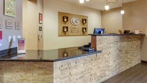 A hotel reception area with a stone counter, a sign for 'Comfort Suites', and a digital screen. - Comfort Suites Glendale - State Farm Stadium Area (Glendale)
