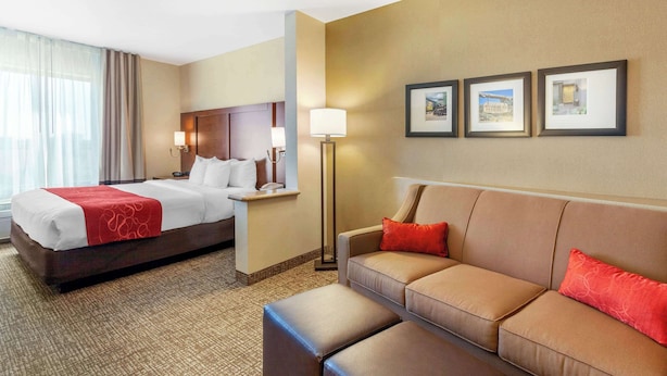 A hotel room with a bed, a sofa, a nightstand, and a lamp. There are three framed pictures on the wall. - Comfort Suites Glendale - State Farm Stadium Area (Glendale)