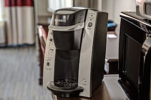 A Keurig coffee machine with a drip coffee maker, a power button, and a brew button.