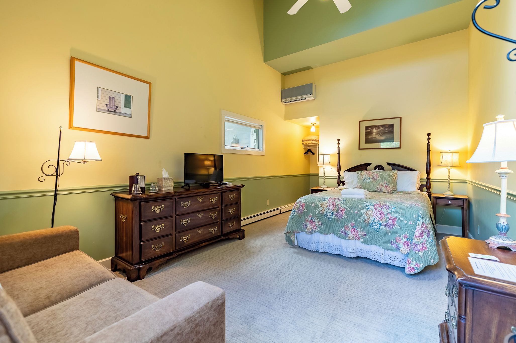 Une chambre d’hôtel équipée d’un lit, d’une commode, de chaises et d’un téléviseur.