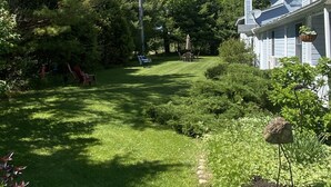 A well-maintained lawn with a pathway leading to a house. - The Sylvan Inn (Glen Arbor)