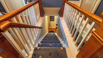 A wooden staircase with white railings leading to a landing.