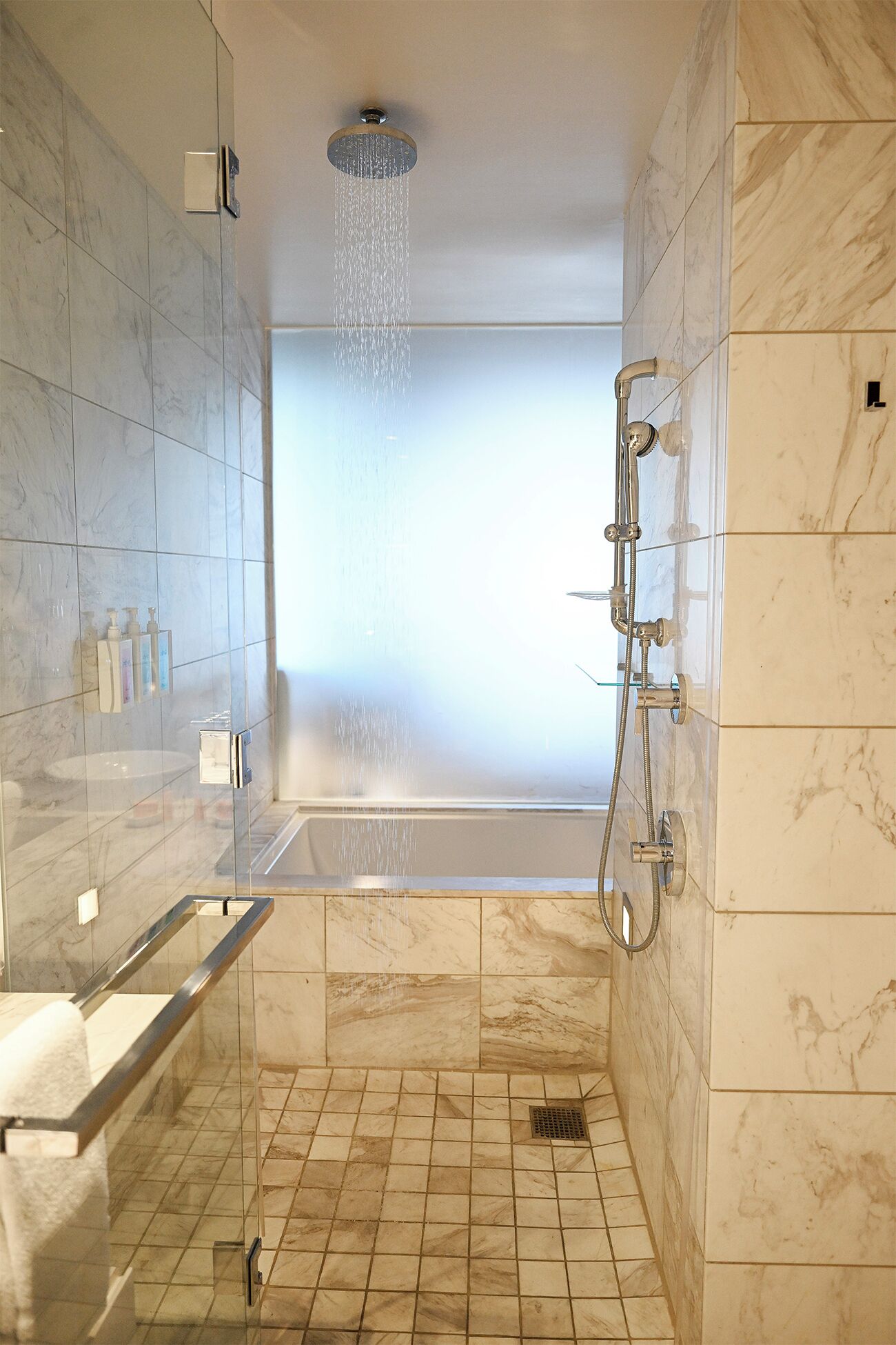 Een moderne badkamer met een douche, een bad en een toilet.