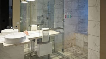 Un bagno moderno con due lavabi, cabina doccia in vetro e pavimento in marmo.