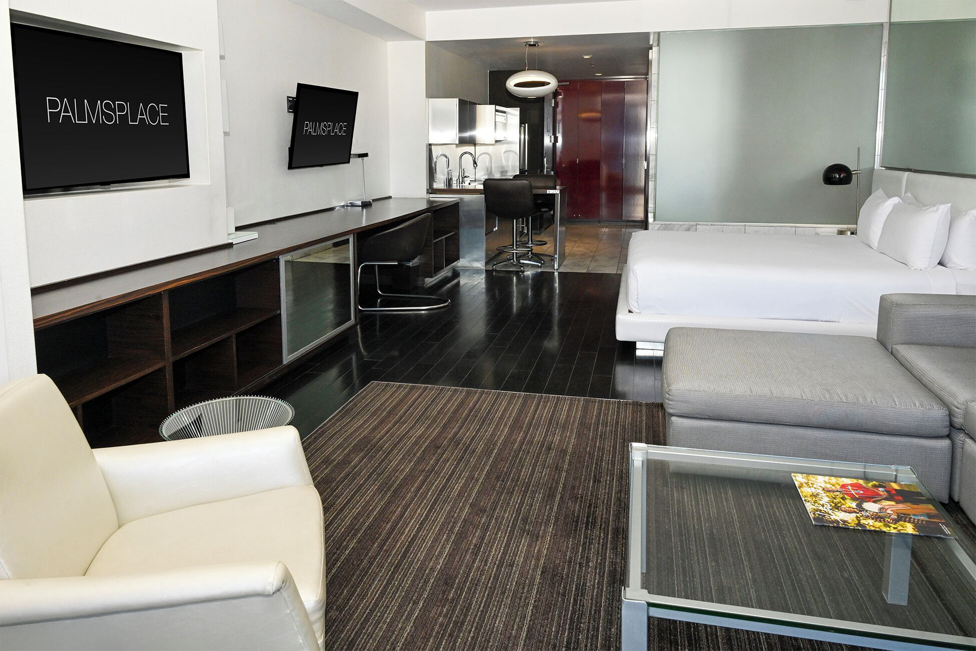 Une chambre d’hôtel moderne équipée d’un lit, d’un canapé, d’une télévision et d’un espace bureau.