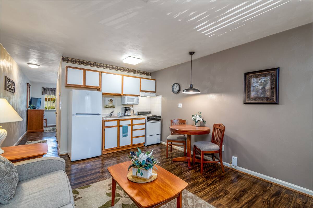 A compact living space with a kitchenette, dining area, and a sofa.