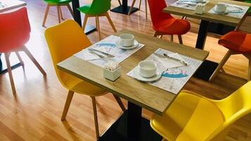 Un comedor con mesas de madera y sillas de colores.