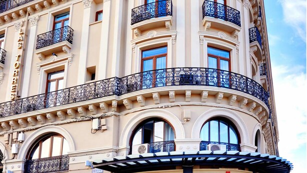 Un edificio histórico con fachada curva, varios balcones y una entrada destacada que dice "PILAR PLAZA".