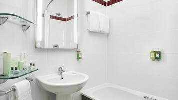 Un baño con cabina de ducha de vidrio, lavamanos pedestal, bañera y espejo.