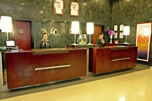 A reception desk with two receptionists, a fish bowl, and framed certificates on the wall. - ibis Kuwait Salmiya (Salmiya)