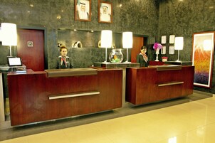 A reception desk with two receptionists, a fish bowl, and framed certificates on the wall.