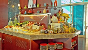 A buffet counter with various fruits, vegetables, and condiments. - ibis Kuwait Salmiya (Salmiya)