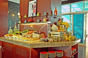 A buffet counter with various fruits, vegetables, and condiments.