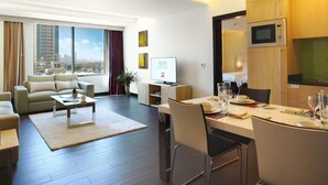 A modern hotel room with a living area, dining space, and a kitchenette. - ibis Kuwait Salmiya (Salmiya)
