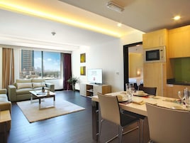 Una habitación de hotel moderna con sala de estar, comedor y kitchenette.