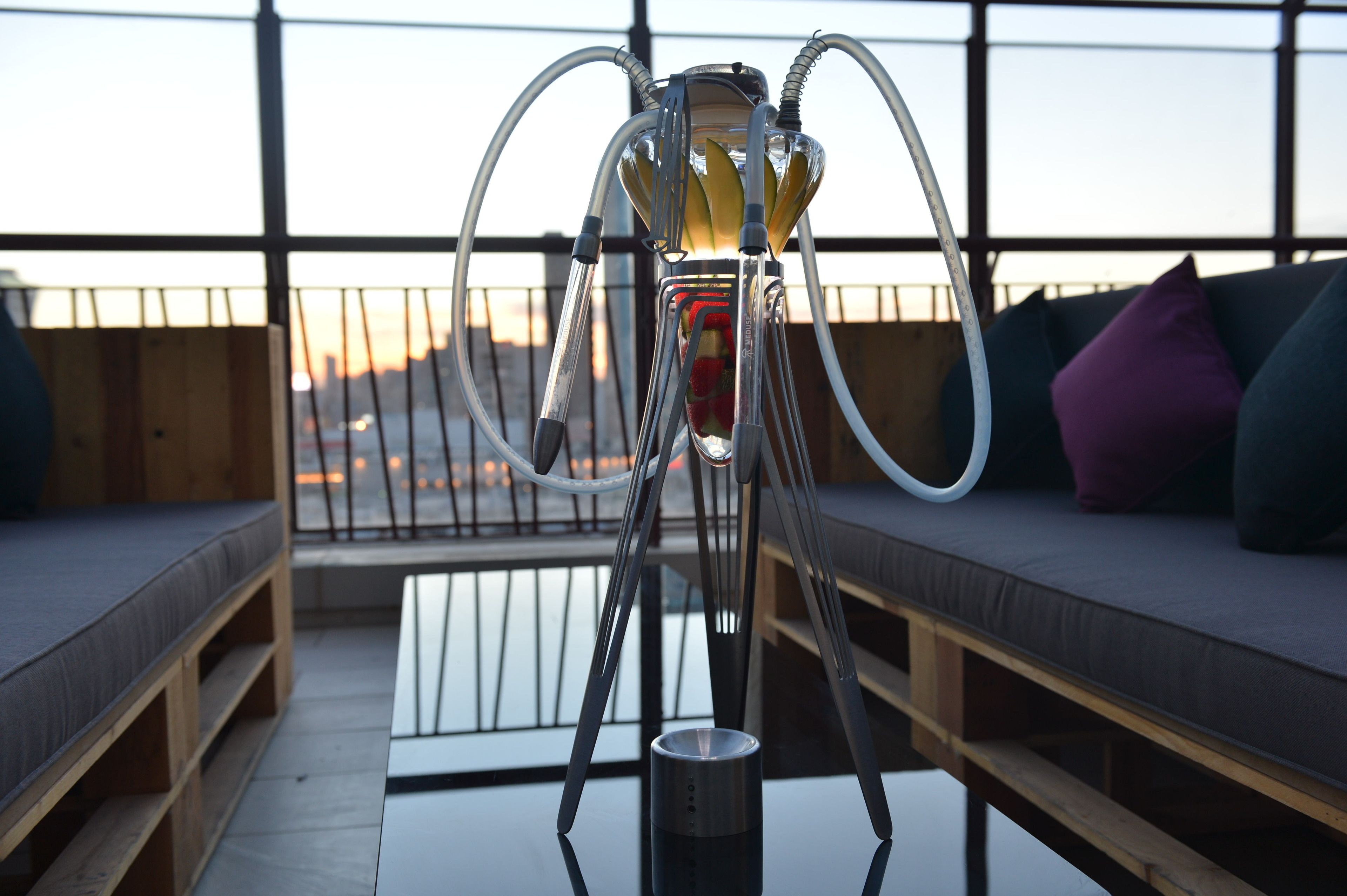 A hookah on a balcony with a view of the sunset.