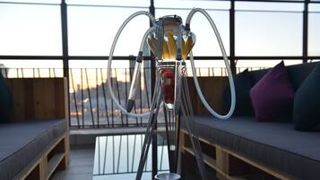 A hookah on a balcony with a view of the sunset.