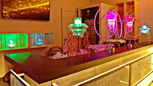 A bar area with neon lights, a television, and a wooden counter. - ibis Kuwait Salmiya (Salmiya)