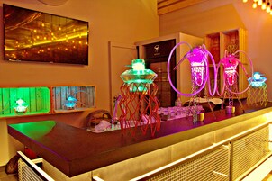 A bar area with neon lights, a television, and a wooden counter.