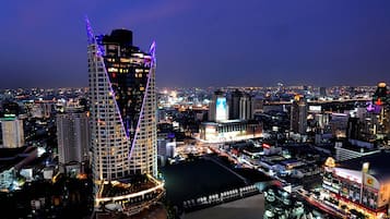 A high-rise hotel with a distinctive triangular structure, surrounded by other buildings and city lights.