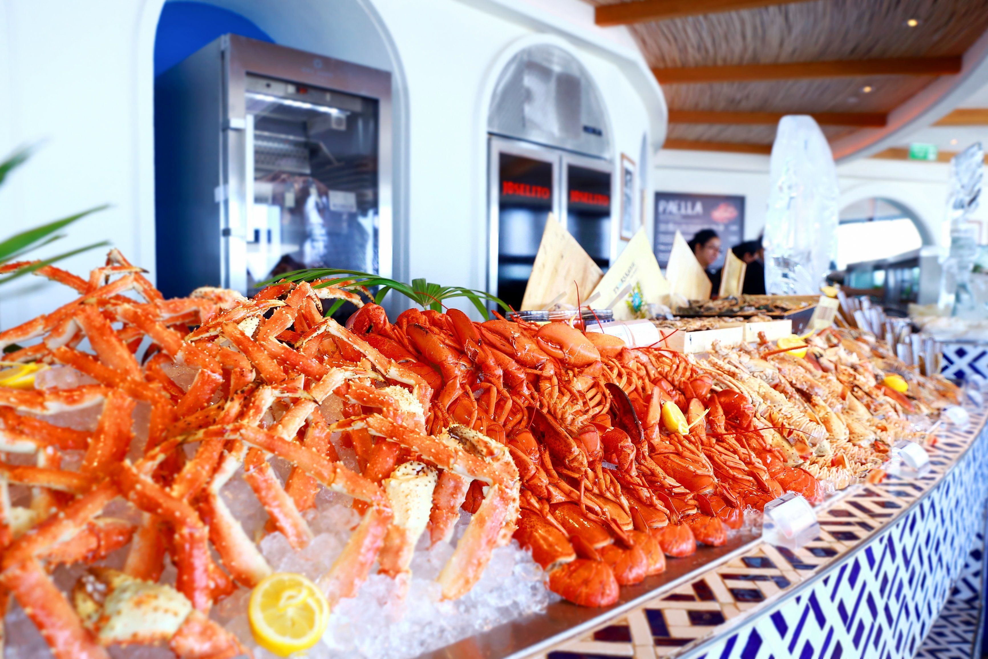 A seafood display with various types of seafood, including lobsters and shrimp, on ice.