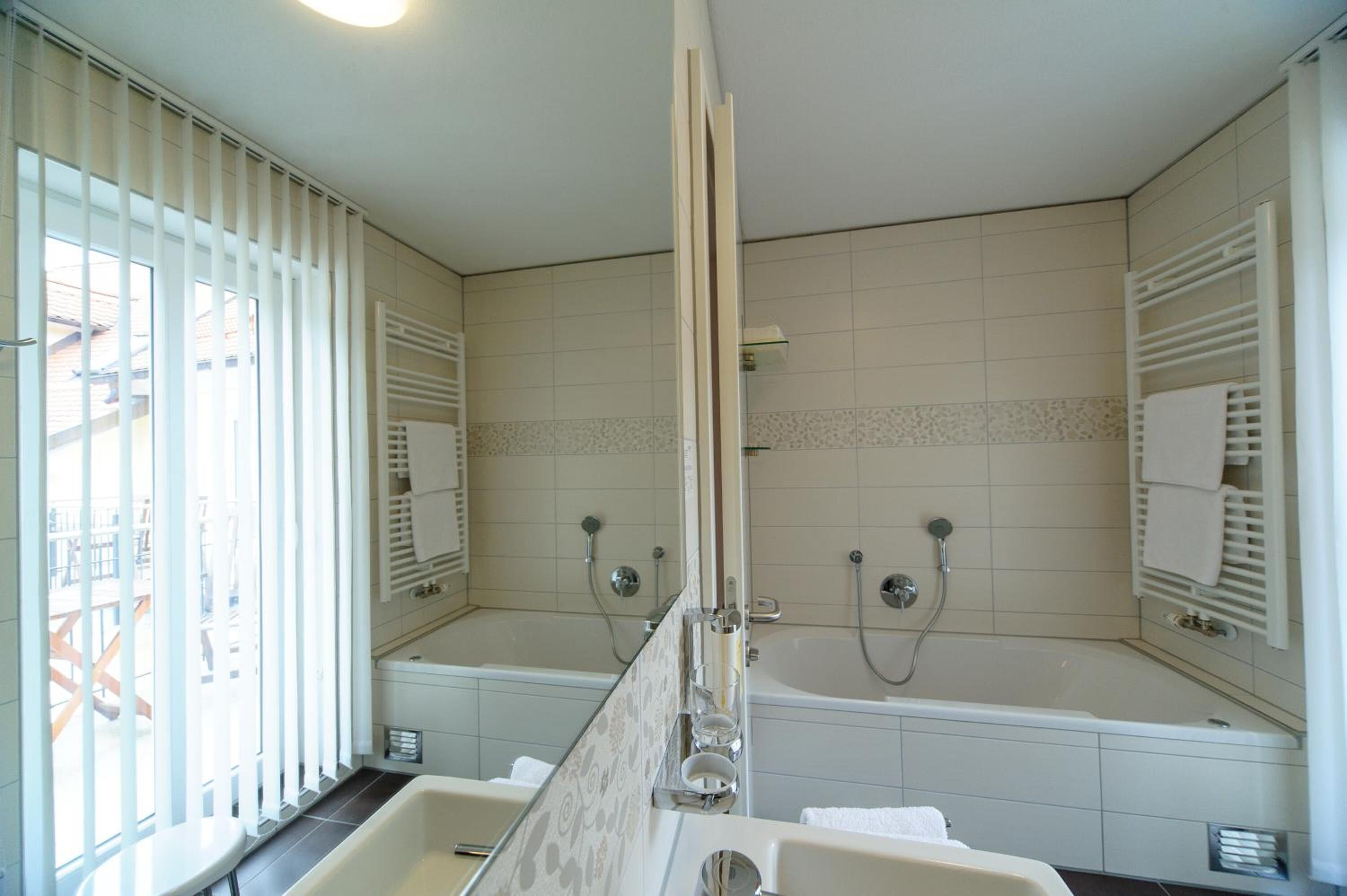 Une salle de bain moderne avec deux lavabos, une baignoire et une douche.
