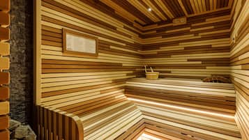 Un sauna avec des lambris en bois aux murs et au plafond, un banc et un seau.