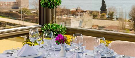 A table set for a meal with a view of a body of water and historic buildings.
