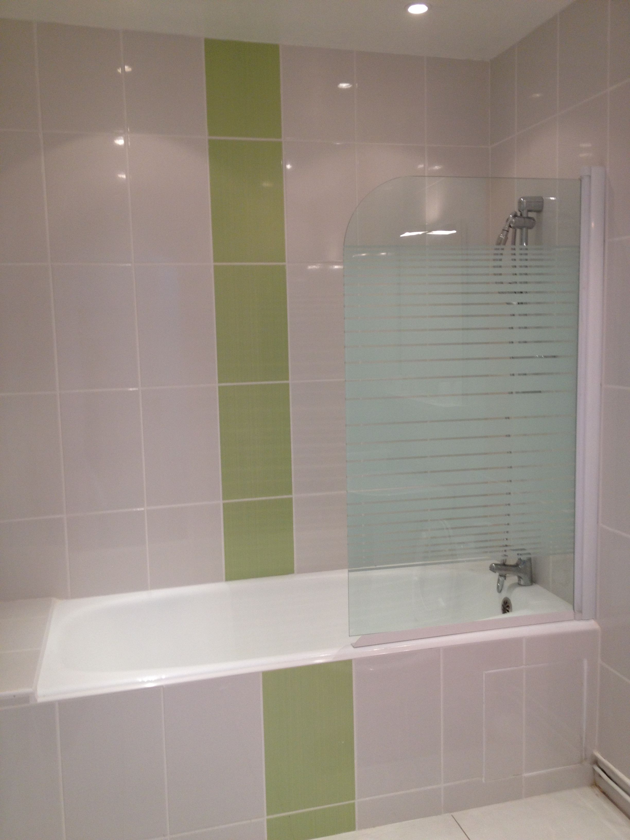 Une salle de bain équipée d’une baignoire, d’une douche et d’un espace de douche séparé par des parois en verre.