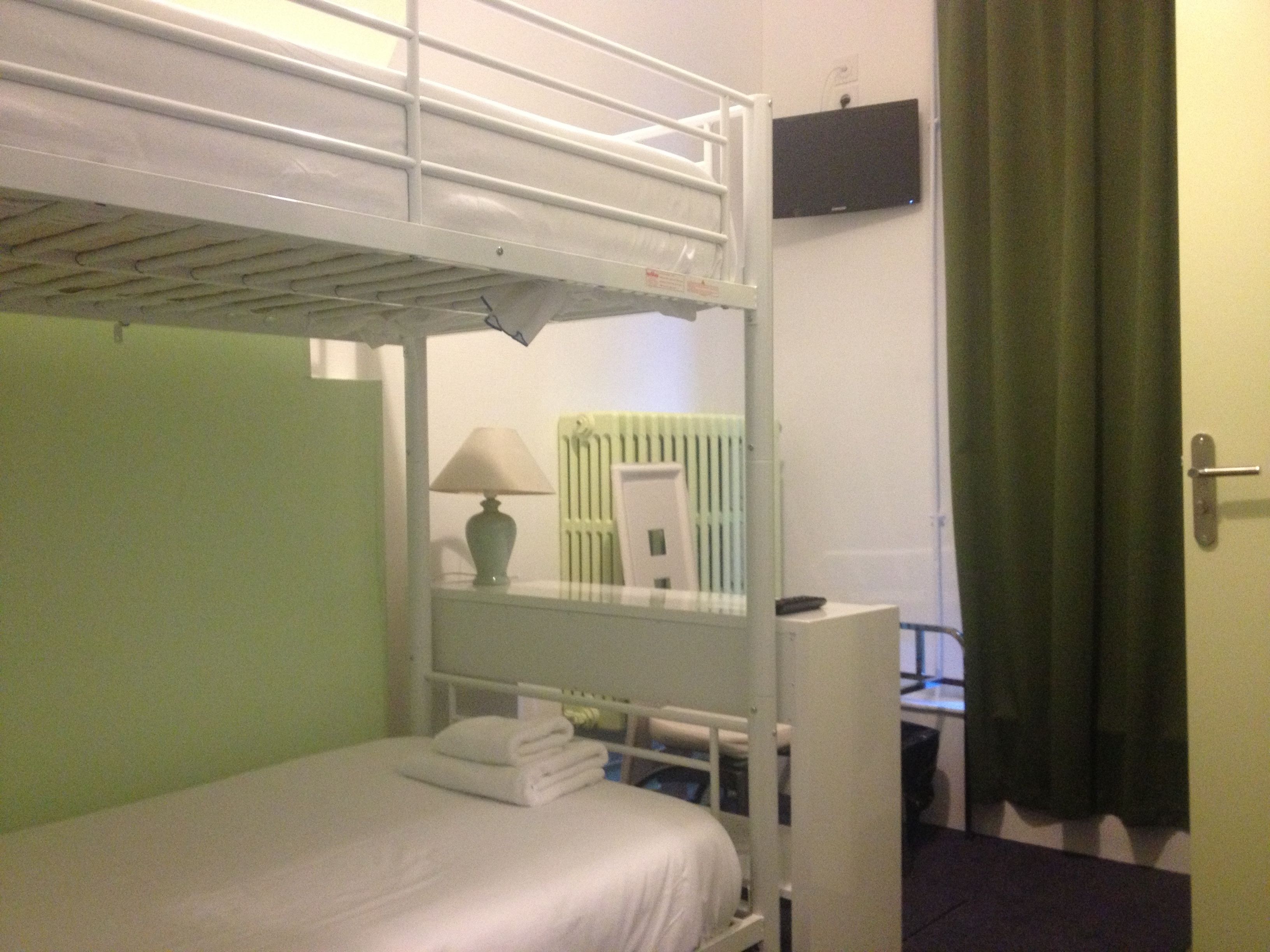 Camera con letto a castello, una scrivania e una lampada.