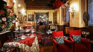 Une pièce avec une table à manger dressée pour le repas, un fauteuil rouge et un escalier menant à une autre pièce.