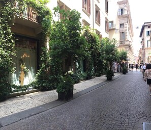 A cobblestone street lined with trees and buildings. - Hotel Gabbia d'Oro (Verona)