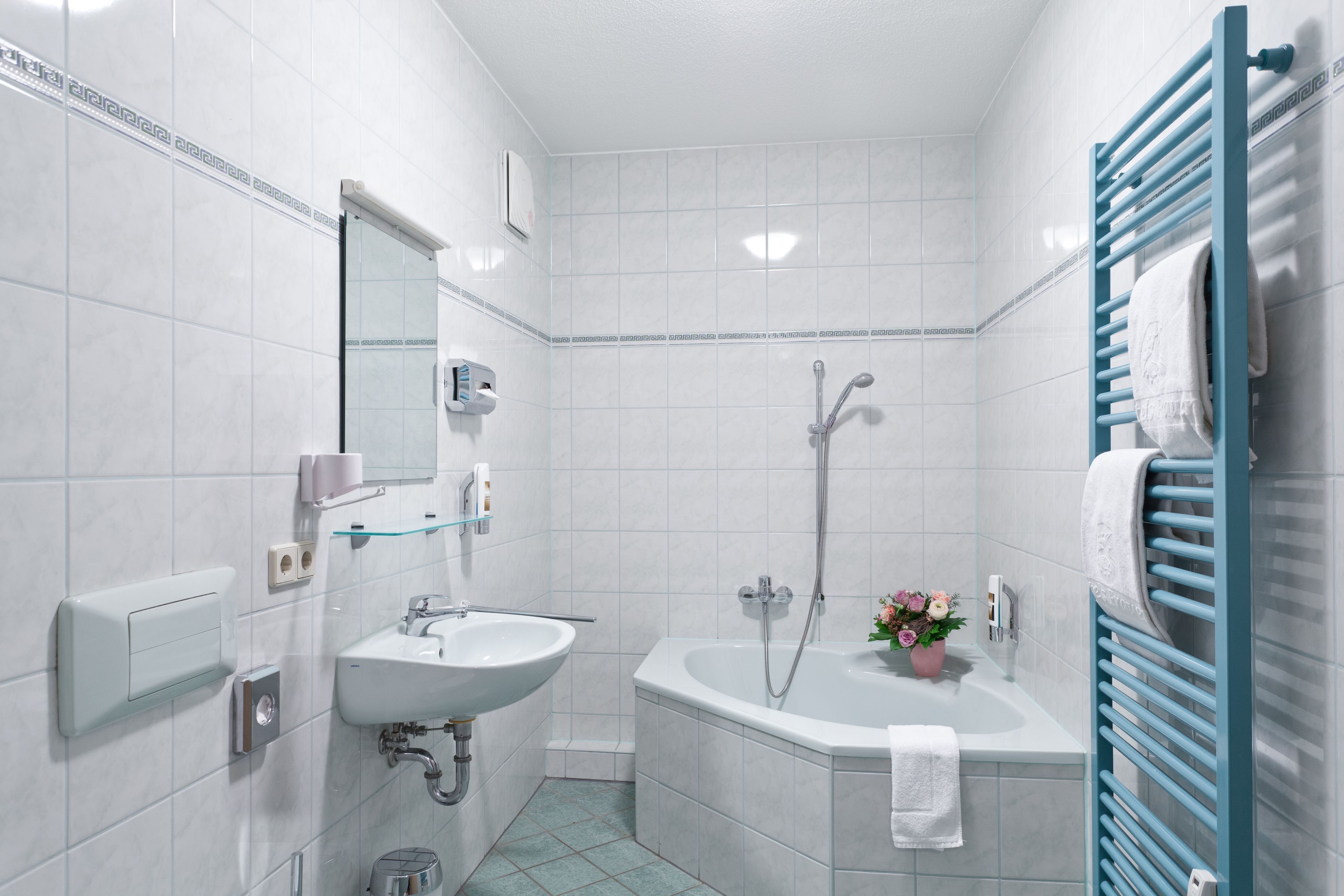 Ein modernes Badezimmer mit Waschbecken, Spiegel und Dusche.