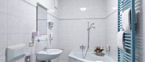A modern bathroom with a sink, mirror, and shower.