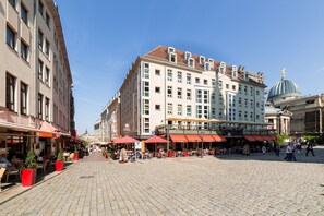 A public square with outdoor seating, a large building with a dome, and a pedestrian walkway. - Aparthotel Münzgasse (Dresden)