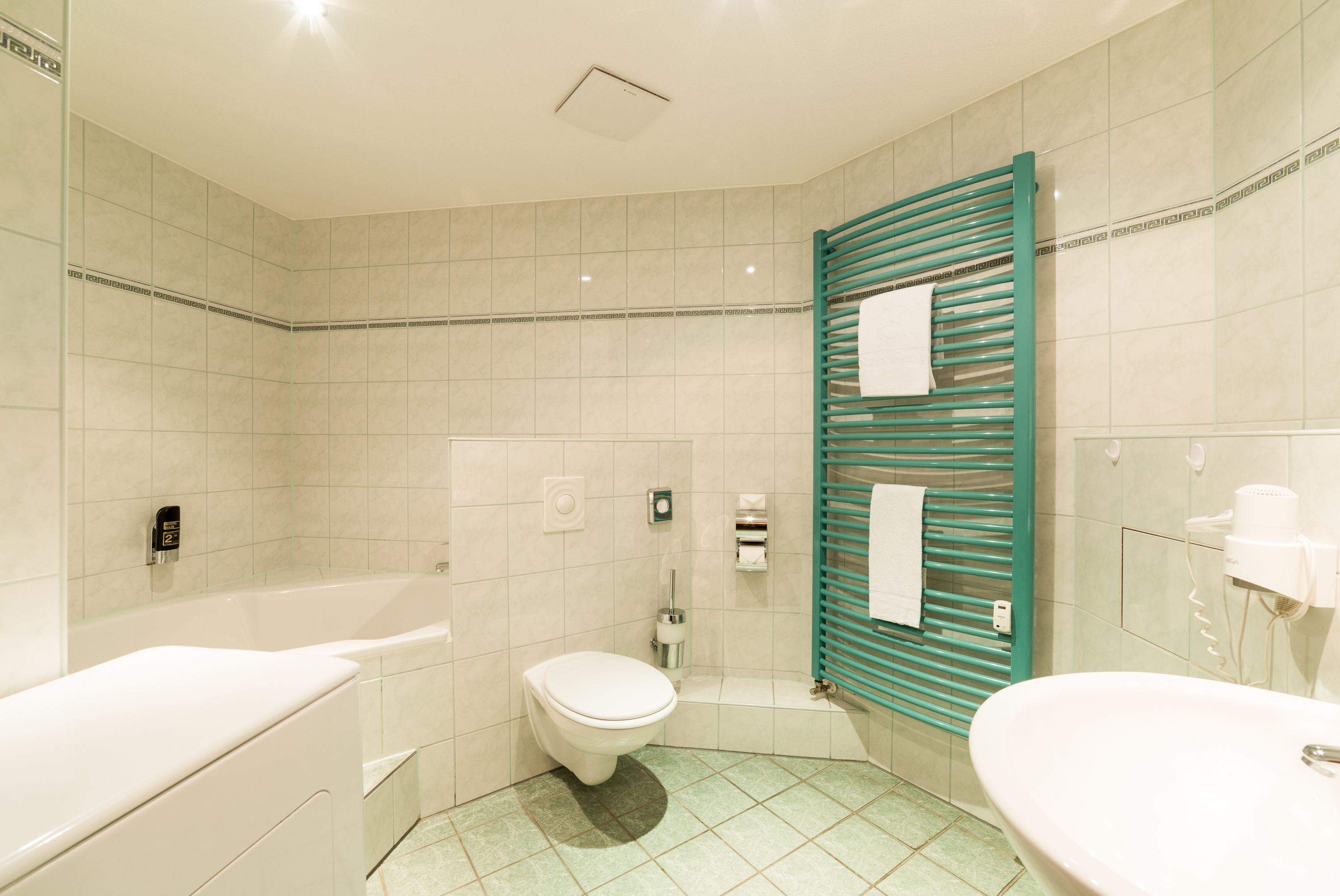 A bathroom with a bathtub, toilet, and sink.