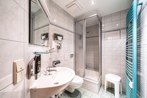 Een bad/douchecombinatie, een haardroger, handdoeken, shampoo