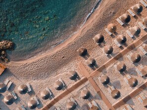 På stranden, solsenger, parasoller og strandhåndklær