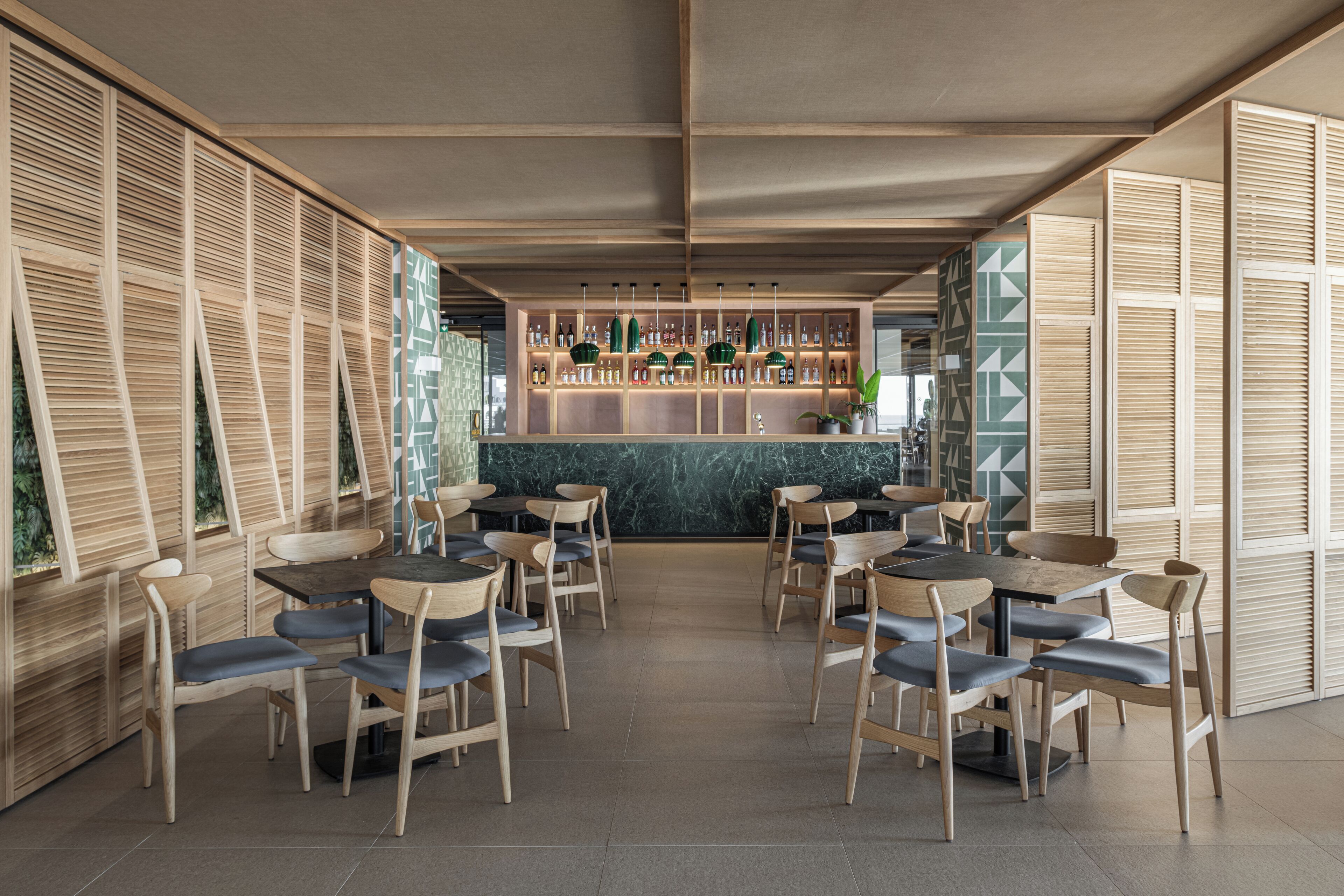 A modern restaurant with wooden furniture and a bar area.